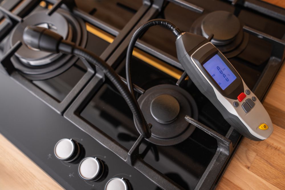 Gas Stove Inspection With Leak Detector Electrical cooktop tested with gas leak detector, highlighting the role of appliance maintenance in home safety.