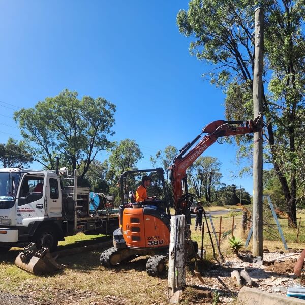 Dave Fenech Electrical Services team installing a new private power pole in Sydney using an excavator and service truck Dave Fenech Electrical Services team installing a new private power pole in Sydney using an excavator and service truck