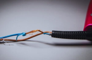 Dave Fenech Electrical Services electrician highlighting the dangers of exposed copper wiring in damaged household cables